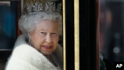 Britain's Queen Elizabeth II travels in a carriage from Buckingham Palace towards the Houses of Parliament in London, May 27, 2015. 