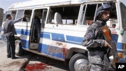 An Iraqi policeman stands guard near a destroyed bus at the site of a bombing in Basra, Iraq's second-largest city, 550 kilometers southeast of Baghdad, March 6, 2011