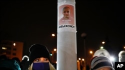 People gather to commemorate Roman Bondarenko, an anti-government protester who died in hospital following a severe beating by security forces, on fortieth day after his death Dec. 21, 2020, with a photo of him on the pole with the words ‘do not forget’.