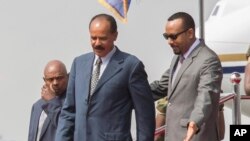 Eritrean President Isaias Afwerki, foreground left is welcomed by Ethiopia's Prime Minister Abiy Ahmed upon his arrival at Addis Ababa International Airport, Ethiopia, Saturday, July 14, 2018. (AP Photo Mulugeta Aye