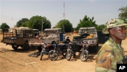 Wani dan sanda yana duba gine gine da ababan hawa da kuma makamai bayan harin da kungiyar Boko Haram ta kai a Damaturu ranar 25 da 25 ga watan Oktoba. An dauki hotunan ranar 28 ga watan Oktoba, 2013.