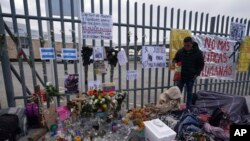 Sebuah altar dengan lilin dan foto menutupi pagar di luar pusat penahanan imigrasi di Ciudad Juarez, Meksiko, yang menjadi lokasi kebakaran mematikan, Kamis, 30 Maret 2023. (AP/Fernando Llano)