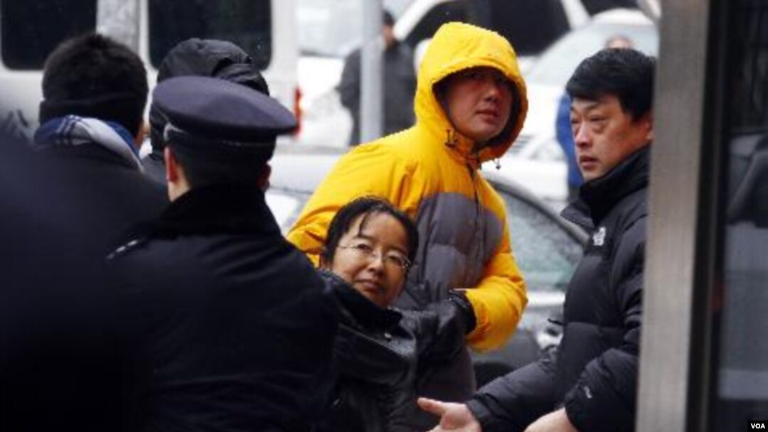 Seorang aktivis Hak Asasi Manusia Tiongkok diseret menjauhi wartawan dan para diplomat di luar gedung pengadilan tempat Ni Yulan dan suaminya, Don Jiqin akan diadili di Beijing (29/12).