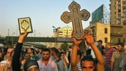 یک زن مسلمان مصری با در دست گرفتن یک جلد کلام اله مجید یکپارچگی خود را با مسیحیان مصری که دست به تظاهرات زده بودند؛ نشان می دهد.
عکس از خبرنگار صدای آمریکا - مصر - ۱۰ اکتبر ۲۰۱۱