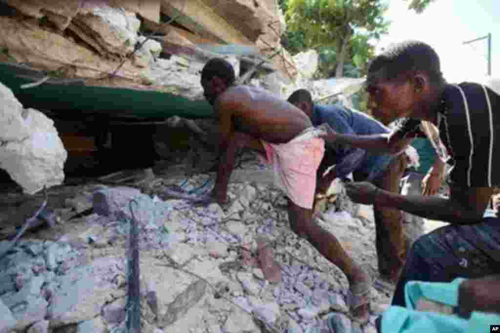 PORT-AU-PRINCE, HAITI - JANUARY 15: People try to unbury their loved ones that were buried under the rubble of their home after it was destroyed by the massive earthquake January 15, 2010 in Port-au-Prince, Haiti. Planeloads of rescuers and relief supplie