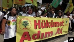 Kurds hold a banner that reads 'government, take steps' during a protest in Ankara, Turkey. Kurdish rebels on Friday gave Turkey a 'final warning' to take steps that would move forward peace talks, July 13, 2013. 