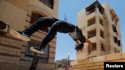 Mariam Emad dari Parkour Egypt atau “PKE” melatih keterampilan melakukan gerakan parkour di gedung-gedung di pinggiran Kota Kairo, Mesir, 20 Juli 2018.