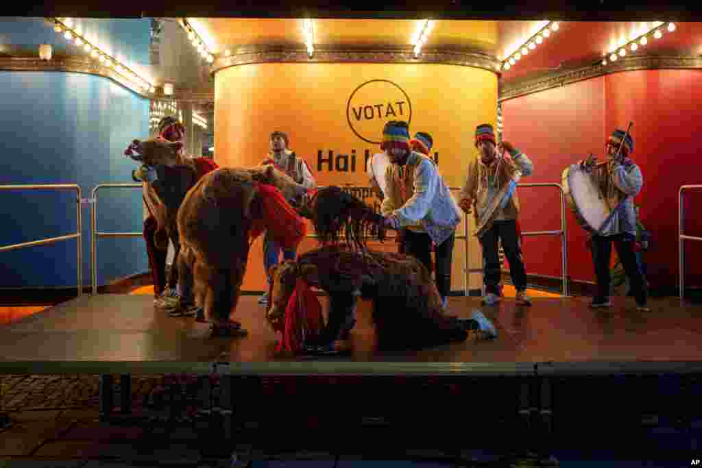 People wearing costumes perform a ritual dance before the speech of George Simion, leader of the Alliance for the Unity of Romanians (AUR) shortly before polls closed in the country's parliamentary elections, in Bucharest, Romania, Dec. 1, 2024.