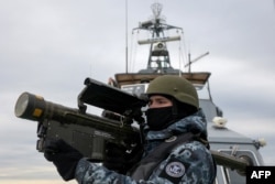 Seorang prajurit Ukraina memegang senjata anti-pesawat MANPADS (Man-Portable Air-Defence Systems) "Stinger" saat mereka memindai kemungkinan sasaran udara, di atas kapal Penjaga Maritim dari Dinas Perbatasan Negara Ukraina, 18 Desember 2023. (Foto: AFP)