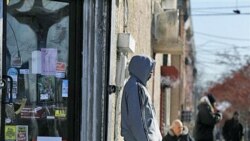 A man stand outside a small store in Camden, New Jersey, which has the highest poverty rate in the nation.