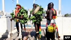 Des personnes vêtues de costumes typiques accueillent les invités lors de la cérémonie d'ouverture et de l'inauguration du nouveau musée des civilisations noires, à Dakar, le 6 décembre 2018.