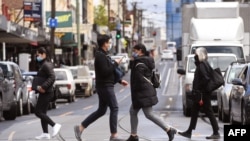 Orang-orang menyeberang jalan di Melbourne pada 11 Oktober 2021, selama penguncian akibat COVID-19 saat Sydney mengakhiri penguncian 106 hari. (Foto: AFP/William West)