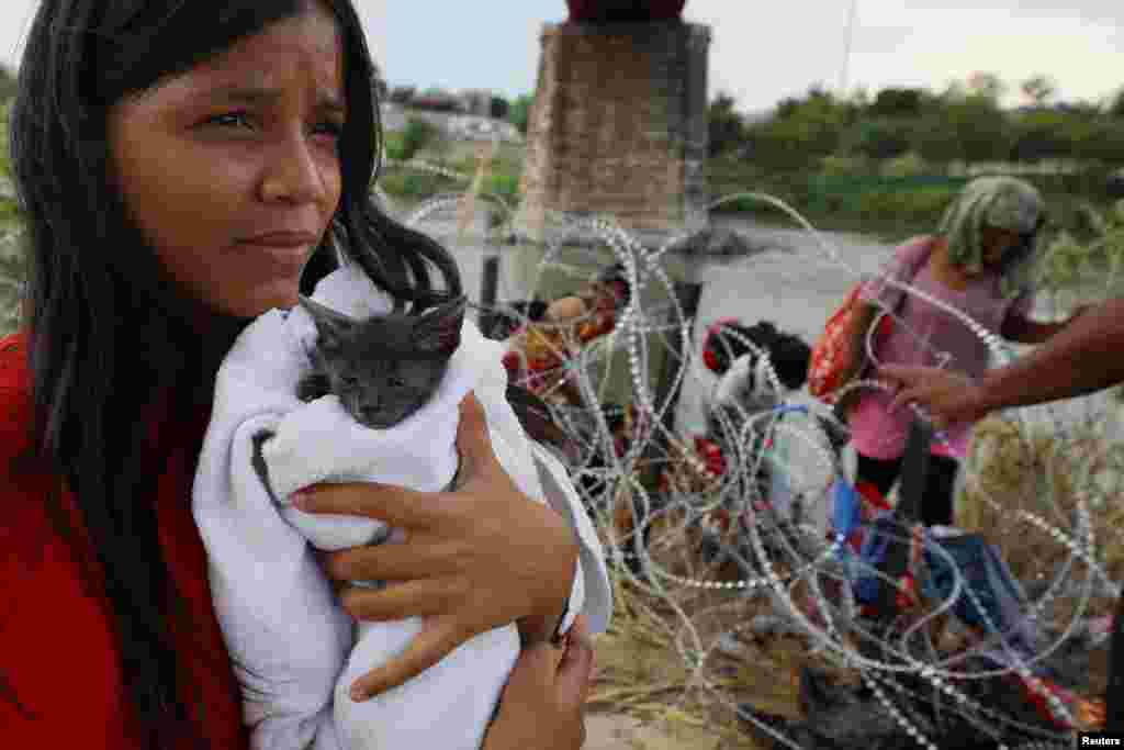 A migrant from Venezuela holds her cat named &quot;Grey&quot; that she picked up along the route, after crossing the Rio Grande and making her way through the razor wire into the United States in Eagle Pass, Texas, Sept. 26, 2023.