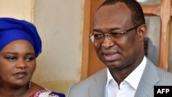 Anicet Georges Dologuele s'entretient avec des journalistes, aux côtés de sa femme, après avoir voté pour des élections législatives retardées et un second tour de scrutin présidentiel, dans un bureau de vote de Bangui, le 14 février 2016.