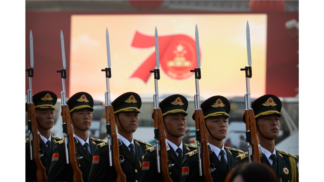FILE - Members of a Chinese military honor guard stand at attention during a rehearsal before a parade to commemorate the 70th anniversary of the founding of Communist China, in Beijing, Oct. 1, 2019.