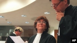 Prosecutor, Justice Louise Arbour, centre, talks to Mark Harmon, right, Senior Trial Attorney, shortly before the beginning of the hearing at the International Criminal Tribunal for former Jugoslavia in The Hague, file photo. 