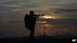 FILE - A Pakistani border security guard stands alert at Pakistan-Afghanistan border post, Chaman in Pakistan, May 5, 2017. The top American general in Afghanistan says Pakistan maintains ties with the Haqqani terrorist network.