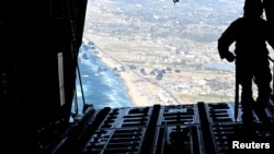 FILE— A U.S. Air Force loadmaster releases humanitarian aid pallets of food and water over Gaza, March 2, 2024. 