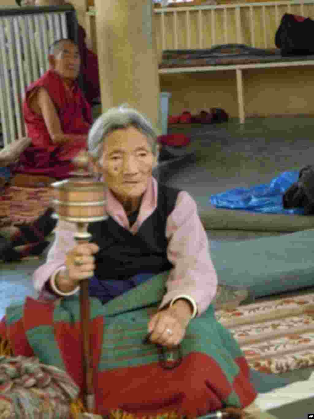 身穿傳統西藏服飾、手持轉經筒的老婦