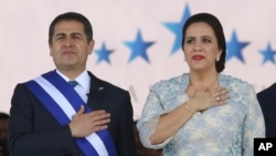 ARCHIVO - El presidente hondureño Juan Orlando Hernández de pie junto a su esposa Ana García, durante la ceremonia de juramentación para su segundo mandato en el Estadio Nacional en Tegucigalpa, Honduras, el 27 de enero de 2018.