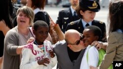 FILE - Congolese children are welcomed by their Italian adoptive relatives as they disembark after landing from Kinshasa, at Ciampino's military airport, on the outskirts of Rome, May 28, 2014. 