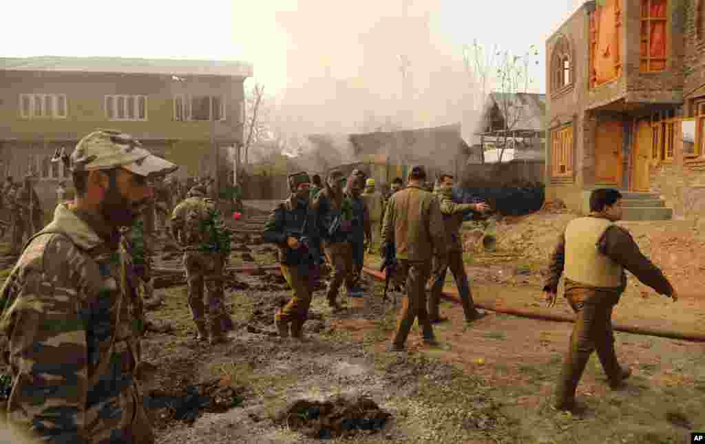 Indian policemen inspect the site of a gunbattle on the outskirts of Srinagar, India, Friday, Dec. 5, 2014.