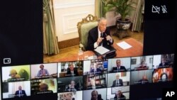 Portuguese President Marcelo Rebelo de Sousa, top, appears on a screen while holding a videoconference with the special advisory body Council State in the Belem palace in Lisbon, Portugal, March 18, 2020.