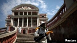 Trabajadores sanitarios desinfectan los exteriores del teatro Amazonas en el estado brasileño del mismo nombre. Brasil es el líder en la región en muertes por coronavirus. Agosto 2 de 2020.