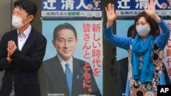 2021年20月27日将举行的一次竞选集会上，日本执政的自民党一个支持者在自民党领袖、首相岸田文雄的竞选广告前挥手。（美联社）