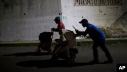 Joel Eduardo Espinar, foreground, and his wife, Yamilet Hernandez, push baby strollers as they start early in the morning toward Arriaga from Pijijiapan, Mexico, Oct. 26, 2018.