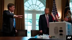El director adjunto del Laboratorio de Propulsión de la NASA, Dave Gallagher, le muestra al presidente Donald Trump el prototipo del respirador.