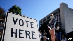 Voters stand in a line as they wait to vote early in Athens, Ga, Oct. 19, 2020. (AP)