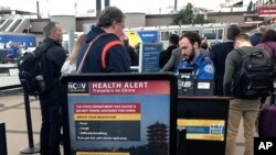 A health alert for people traveling to China is shown at a TSA security checkpoint at the Denver International Airport in Denver, Colorado, March 2, 2020.