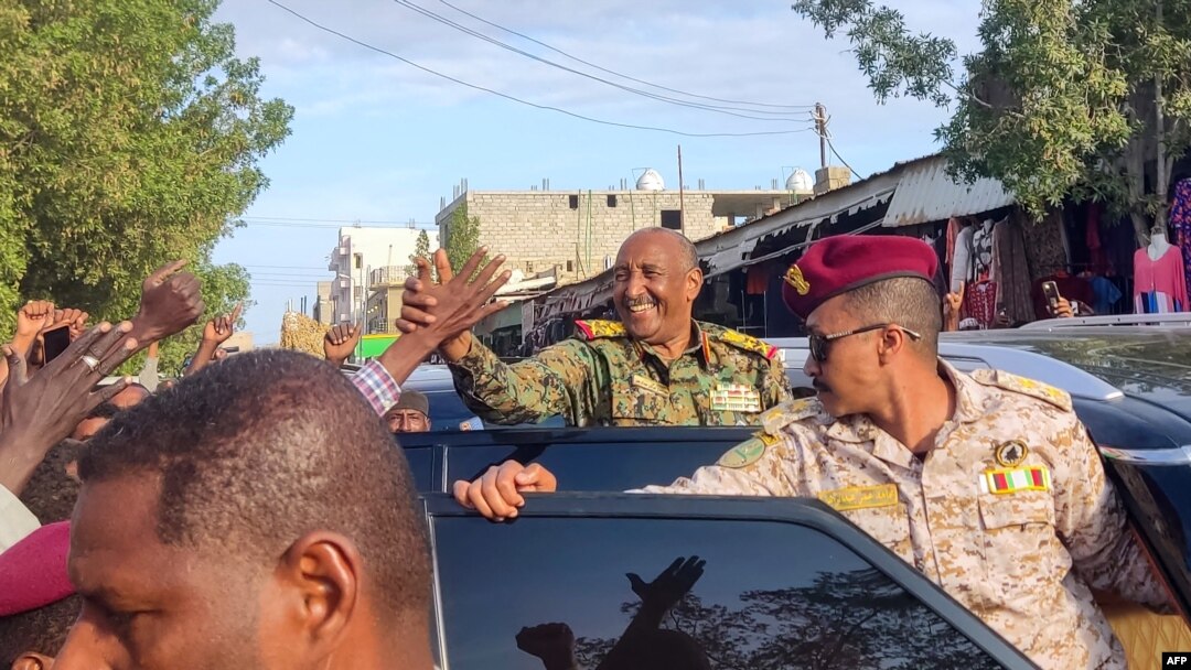 O líder de facto do Sudão, o chefe das forças armadas Abdel Fattah al-Burhan, cumprimenta os apoiantes quando chega ao mercado em Port Sudan, a 29 de dezembro de 2024.