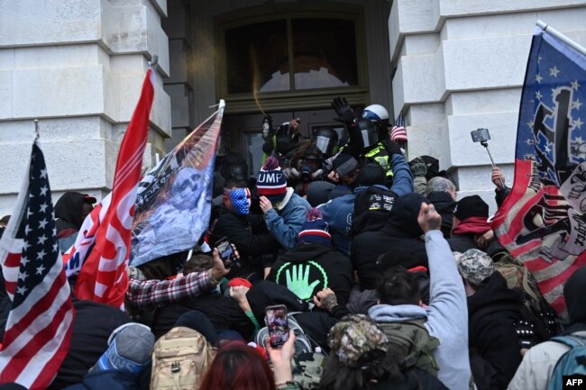 FILE - Trump supporters clash with police and security forces as they storm the U.S. Capitol in Washington, Jan. 6, 2021.