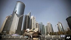 A junk collector rides his tricycle with high-rising buildings as background in Shanghai, China. The prolonged weakness in the U.S. and Europe may be the least of Asia's troubles in 2011, economists say, as the region fights potentially destabilizing infl