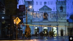 Sri Lankan soldiers stand guard in the rain at St. Anthony's Shrine in Colombo, April 25, 2019. Sri Lanka's Catholic church suspended all public services over security fears, and authorities urged Muslims to pray at home Friday rather than attend a mosque.