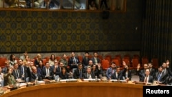 FILE - Ambassadors to the U.N. vote during a United Nations Security Council meeting on North Korea in New York City, Sept. 11, 2017. 