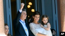 Ditemani istrinya Juliana Awada dan anaknya Antonia, Presiden Argentina yang baru dilantik menyapa orang-orang dari balkoni rumah dinas di Buenos Aires, Argentina, Kamis, 10 Desember 2015. 