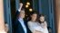 Accompanied by First Lady Juliana Awada and their daughter Antonia, Argentina's President Mauricio Macri greets the crowd from the balcony of the government house in Buenos Aires.