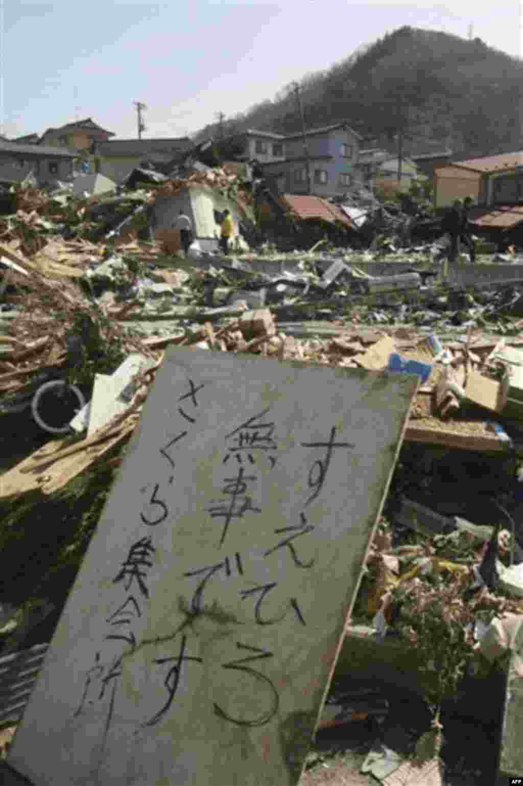 A survivor leaves a message at an devastated area in Onagawacho, northern Japan, Monday, March 14, 2011, three days after a powerful earthquake-triggered tsunami hit the country's east coast. The message says, "Suehiro is safe at Sakura meeting place." (A