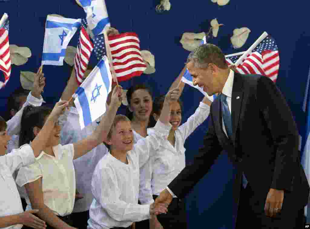 Presiden AS Barack Obama berjabat tangan dengan anak-anak Israel saat ia disambut Presiden Israel Shimon Peres di Yerusalem (20/3). (AP/Sebastian Scheiner)