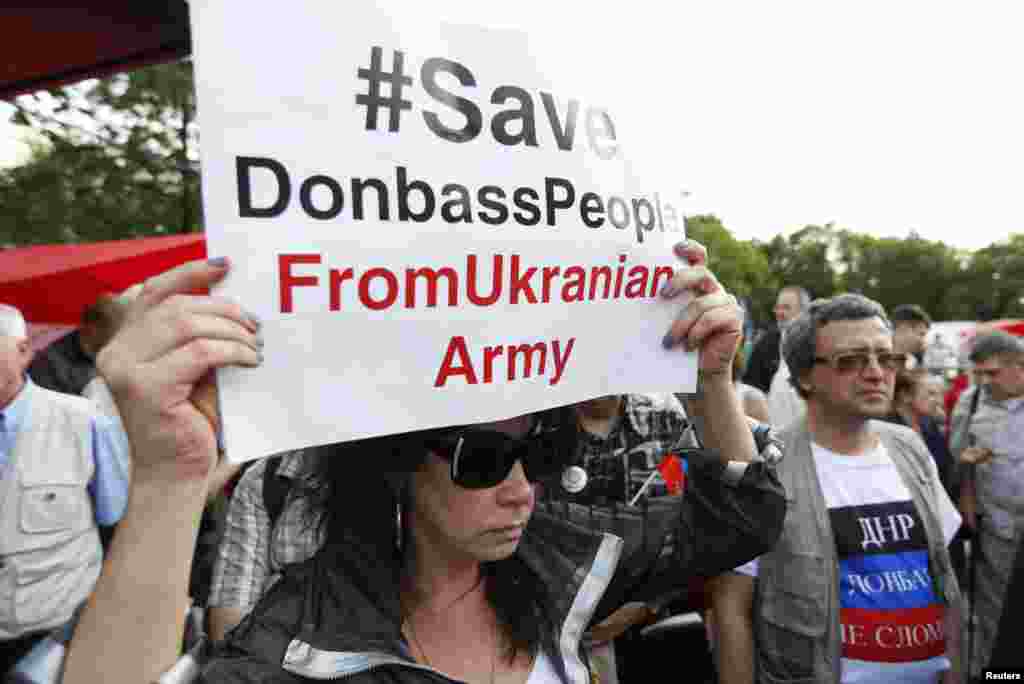 A woman holds a sign a protest against the crisis in eastern Ukraine orgainsed by the Russian communist party in Moscow ,July 3, 2014.