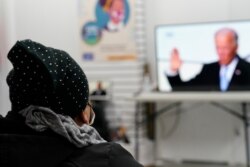 Blanca Cedillos, left, a nanny from El Salvador, watches President Joe Biden's swearing-in ceremony at the Workers Justice Center, an immigrants rights organization, in Brooklyn in New York, Jan. 20, 2021.