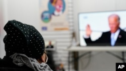 Blanca Cedillos, left, a nanny from El Salvador, watches President Joe Biden's swearing-in ceremony at the Workers Justice Center, an immigrants rights organization, in Brooklyn in New York, Jan. 20, 2021.