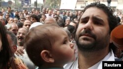 FILE - Alaa Abdel Fattah (R), one of the activists who was summoned by the public prosecutor on whether he had a role in the recent violent anti-Islamists protests, arrives with his wife and child to the public prosecutor's office in Cairo.