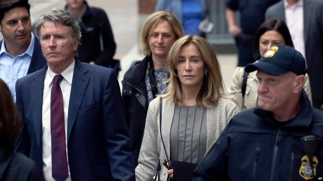 Felicity Huffman, center, departs federal court with her brother Moore Huffman Jr., left, May 13, 2019, in Boston, where she pleaded guilty to charges in a nationwide college admissions bribery scandal. 