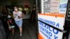 ARCHIVO - Una mujer sale de una tienda que ofrece servicios para enviar remesas a México y Centroamérica en San Diego, el 11 de septiembre de 2020. 