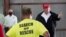 President Donald Trump speaks with first responders as he tours a warehouse being used as a distribution point for relief aid after Hurricane Laura hit the area, Aug. 29, 2020, in Lake Charles, La.