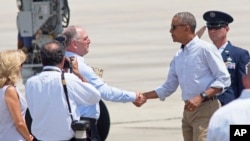 Poignée de main entre le président Barack Obama et le gouverneur de Louisiane John Bel Edwards à l’arrivée de M. Obama à l'aéroport de Baton Rouge, le 23 août 2016.